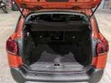 an open trunk of a small car in a garage