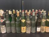 Des bouteilles de vin sont alignées sur une table devant un mur noir
