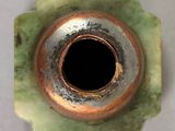 a close up of a green vase with a black hole in it