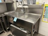 a stainless steel sink in the middle of a kitchen