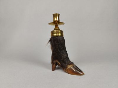 une griffe de petit animal coiffée d'un haut-de-forme