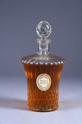 an old fashioned bottle of whiskey sitting on a white surface