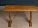 a small wooden table with a chain on it
