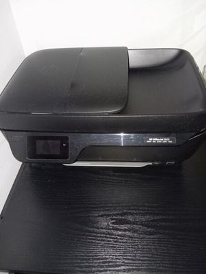 une imprimante noire posée sur un bureau noir