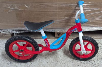 un petit vélo rouge et bleu avec une selle noire