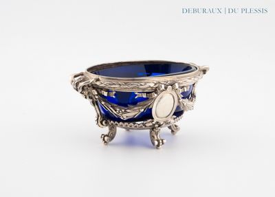 un bol en argent contenant un verre bleu