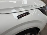 a close up of a white car with a sticker on it