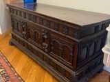 a wooden chest in a room with a rug on the floor