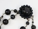 rosary with black beads and silver chain on a white surface