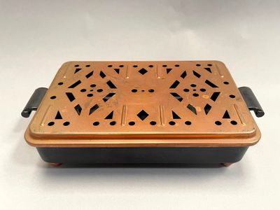 an old copper plate with holes and holes on it