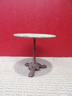 une image représentant une petite table posée sur un sol carrelé, devant un mur rouge