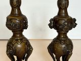 deux vases en bronze posés l'un à côté de l'autre sur une table