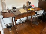 a desk with a chair and a lamp in a room