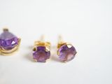 two pairs of amethe earrings and a pair of stud earrings