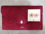 une pochette rouge contenant une paire de boucles d'oreilles