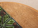 a close up of a wooden table with a tile on it