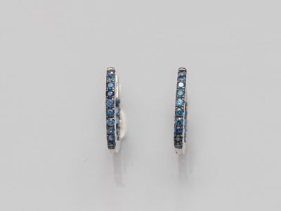 une paire de boucles d'oreilles créoles en saphir bleu et diamants