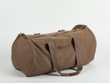 un sac de voyage marron posé sur une surface blanche