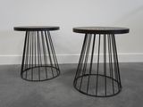 une paire de tables d'appoint noires en fil métallique avec des plateaux en marbre
