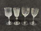 quatre verres à vin sont alignés sur une surface noire