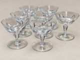 six verres à vin posés sur une table devant un fond blanc
