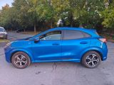the blue car is parked on the side of the road in the parking lot