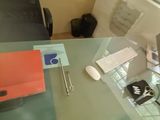 a glass table with a laptop and a cell phone on it
