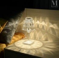 a lamp that is sitting on a table next to a bed
