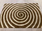 a rug with a spiral design on it on a tiled floor