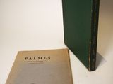 an old book sitting next to a green book on a white surface