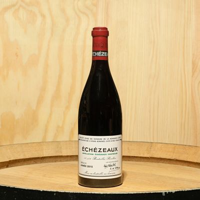 a bottle of wine sitting on top of a barrel