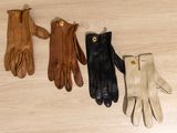 trois paires de gants en cuir posées sur un parquet