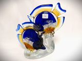 a glass figurine of a fish on a glass base