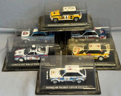Quatre maquettes d'ambulances différentes sont exposées dans une vitrine posée sur une table