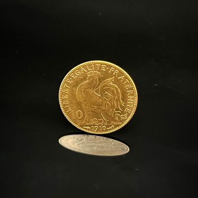 pièce d'or sur fond noir, avec une petite pièce au premier plan