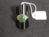 a ring with a green stone on it on a table