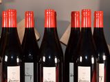 several bottles of red wine are lined up on a shelf