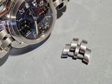 a watch that is laying on a table next to a bracelet