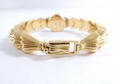 an image of a gold bracelet on a white surface