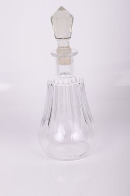 Flacon de parfum en verre transparent muni d'un bouchon en verre, sur fond blanc