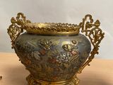 a gold and blue vase sitting on a table next to a pair of scissors