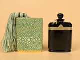 a bottle of perfume next to a box with a tassel on it