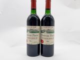 deux bouteilles de vin rouge posées l'une à côté de l'autre sur une surface blanche