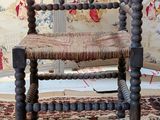 a wooden chair with a woven seat on a rug