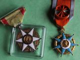 two medals and a medal on a green surface