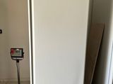 a white refrigerator in the middle of a room with a scale