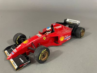 La voiture de course rouge est garée sur une surface grise.
