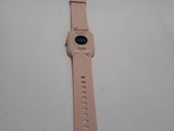 a close up of a pink apple watch on a white surface