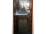 a tall glass case with a clock inside of it
