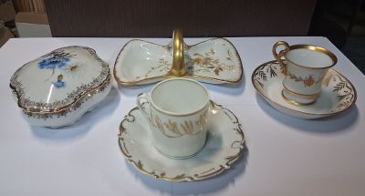 une table blanche recouverte d'une nappe blanche, sur laquelle sont posées des tasses et des soucoupes